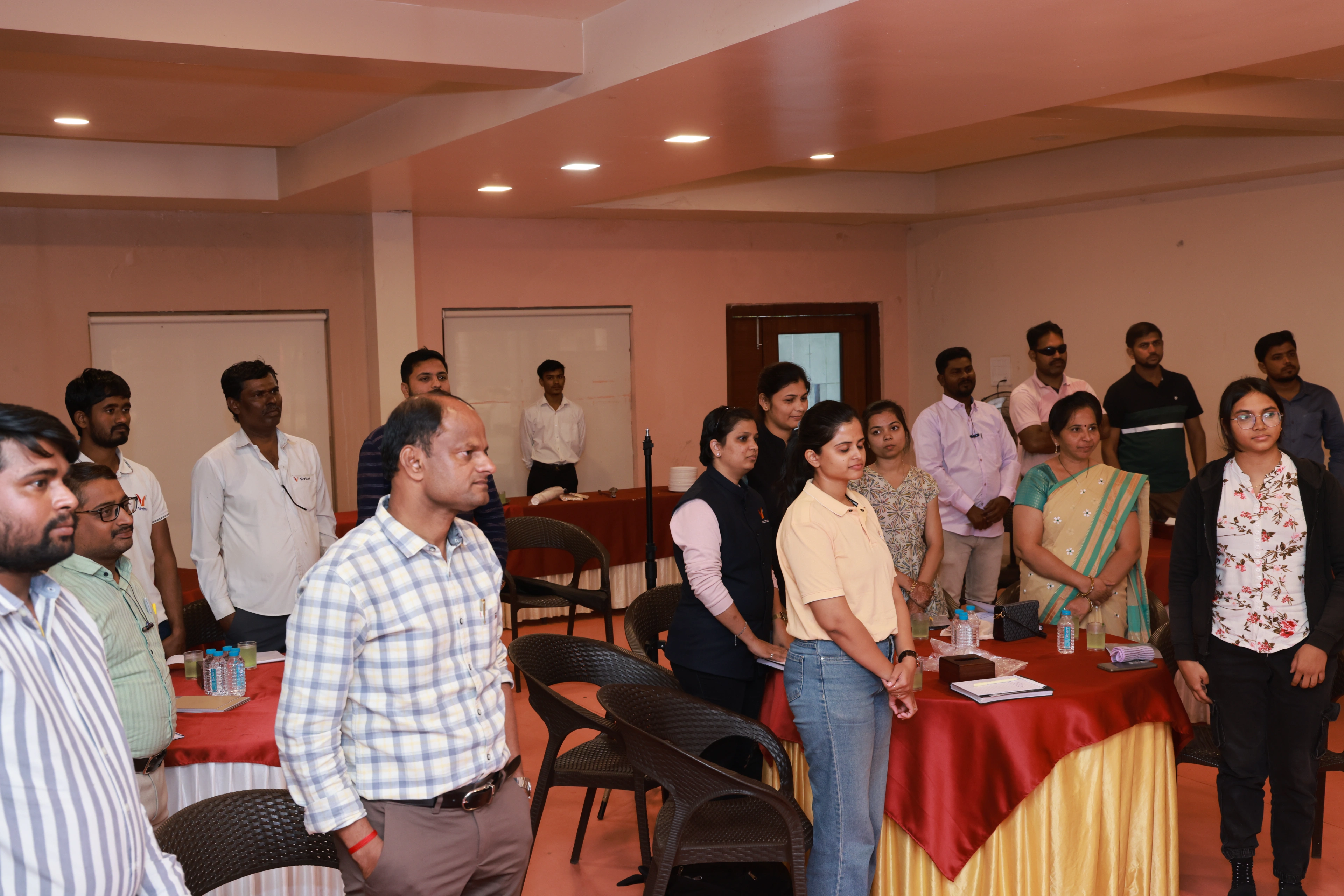 Veritas Engineering & Erectors employees standing between the banquet tables during their motivation and team-building session at Baramati