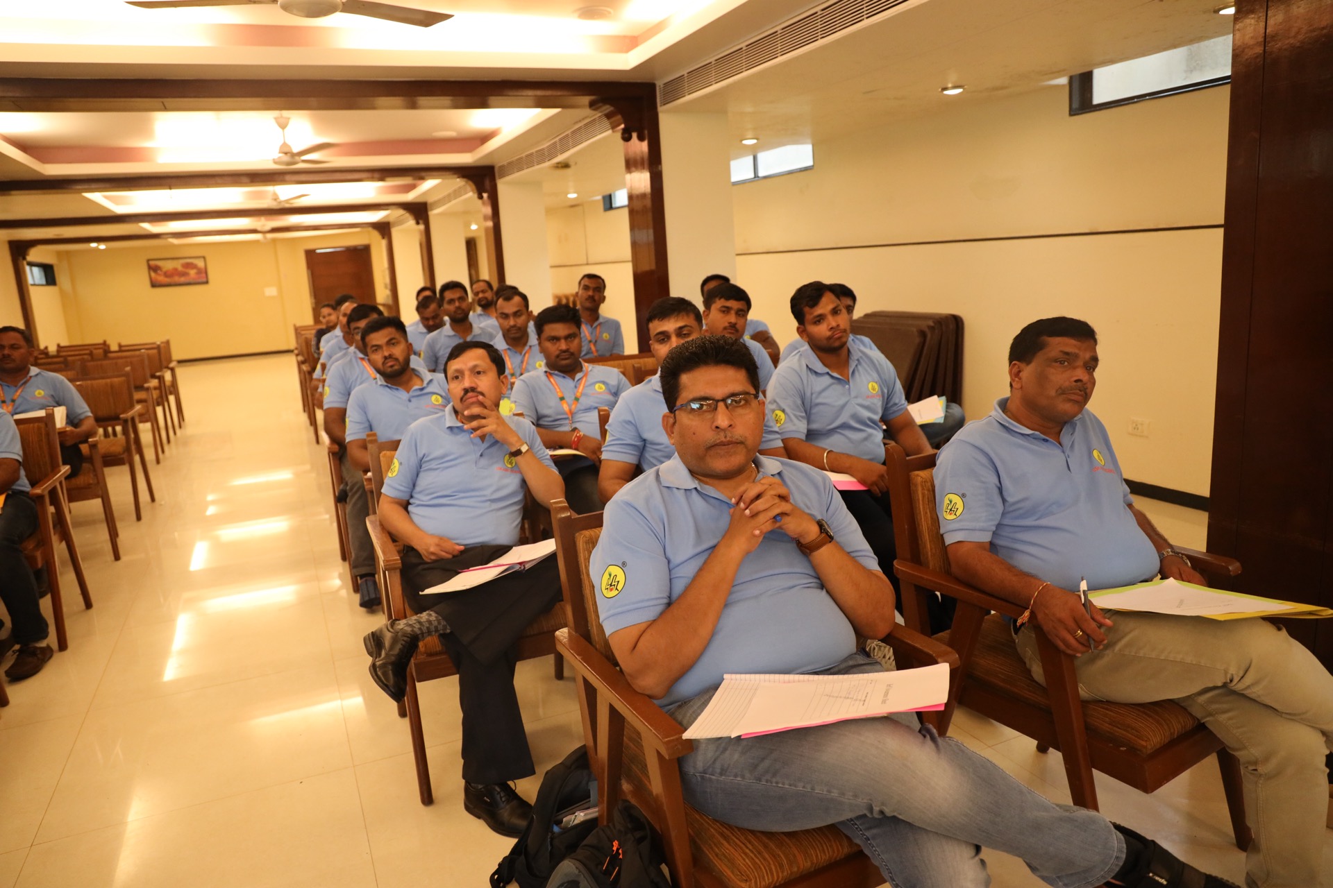 USK Agro Science employees in blue company polo shirts seated with worksheets during the team-building and motivation session, Sangli