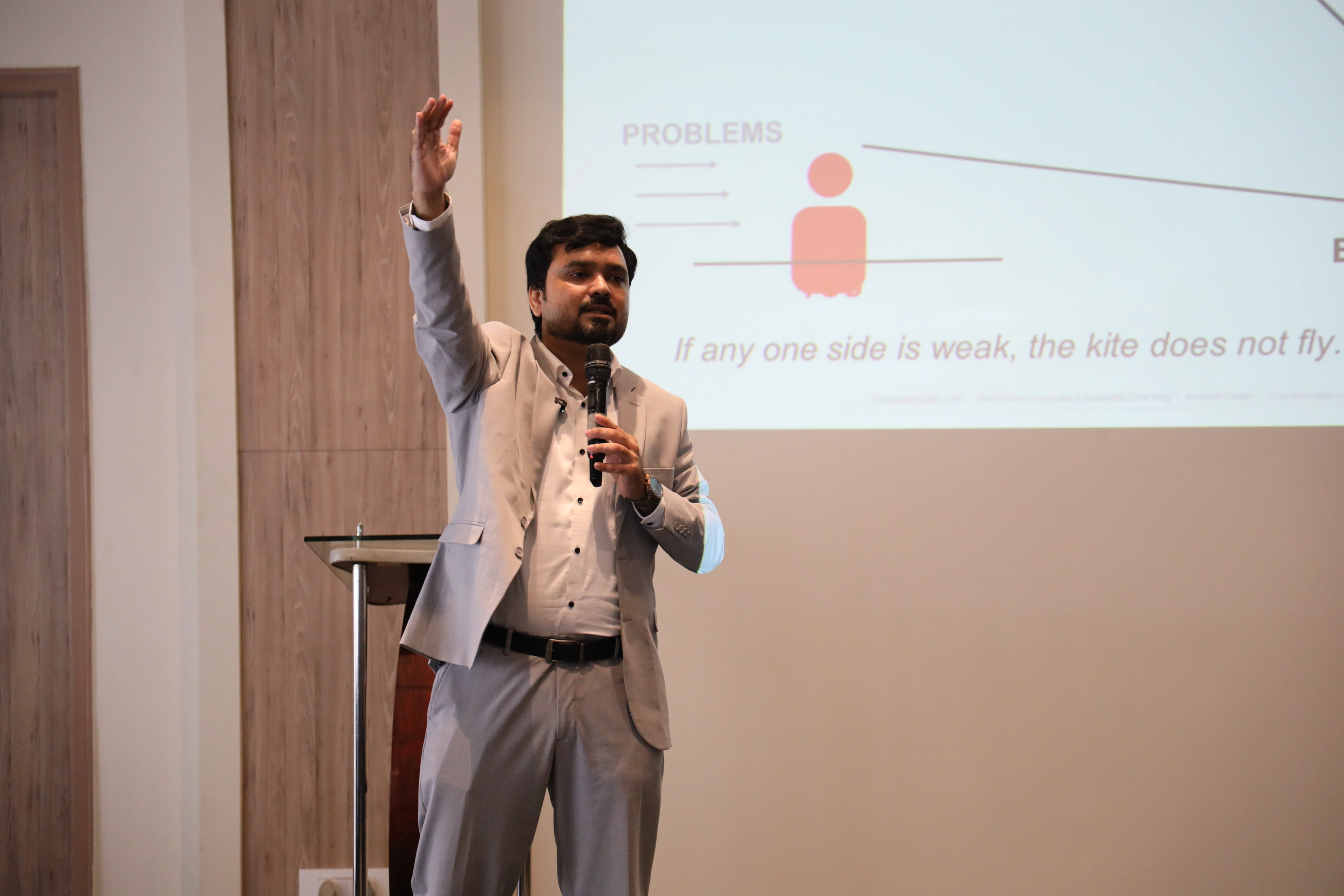 Avinash Chate with arm raised teaching the Winning Kite idea at the Strong Wings Honda training, a kite illustration on the screen behind him, Pimpri-Chinchwad